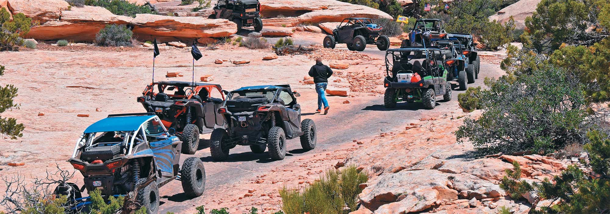 UTVs in different colors on dirt road